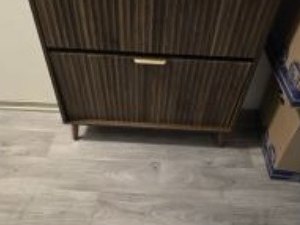 Dark wood two-drawer cabinet with a slatted front and brass pull